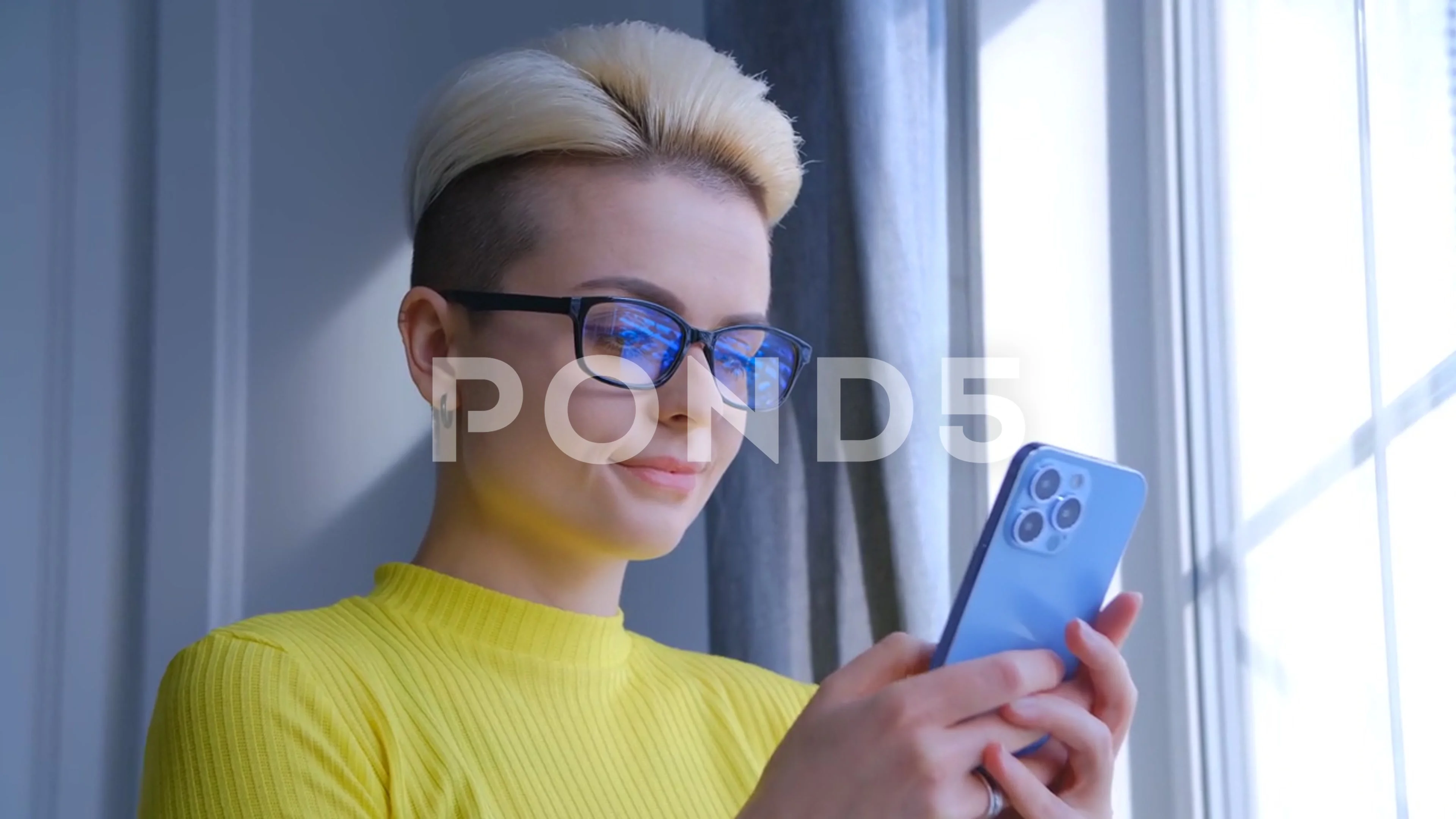 Young tomboy female using new mobile phone for communication online in 4k  video