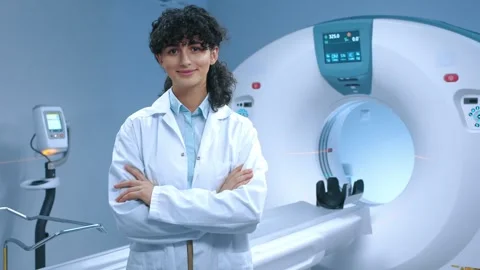 Young tomography specialist posing with crossed arms. Cheerful doctor smiling at Stock Footage 267092226