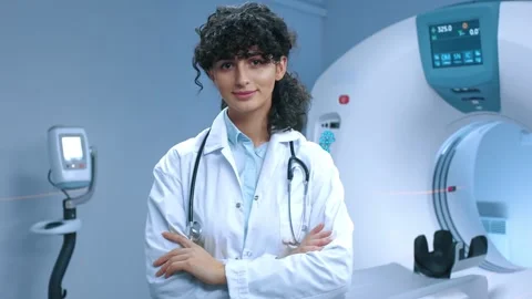 Young tomography specialist posing with crossed arms. Cheerful doctor smiling at Stock Footage 267092248