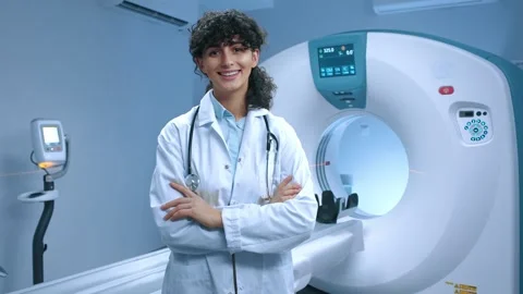 Young tomography specialist posing with crossed arms. Cheerful doctor smiling at Stock Footage 267092263