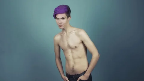 Young topless man with purple bangs posing in studio on gray background Stock Footage 70977212