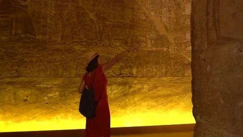 A young tourist looking at the hieroglyphs inside the Abu Simbel Stock Footage 142157316