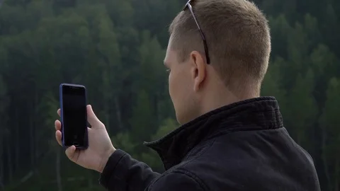 Young tourist man with smart cell phone taking picture selfie of amazing nature Stock Footage 80013530