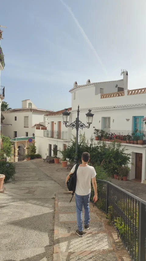 Young tourist man walking down a spanish village street Stock Footage 344692368