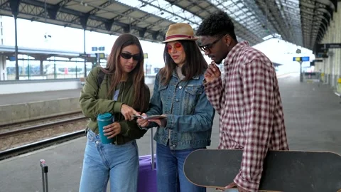Young tourists discussing directions on train station platform Stock Footage 311809446