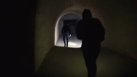 Young tourists explore the dungeon, dark tunnel. Stock Footage 199125976