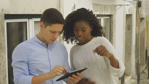 Young tourists looking at map on digital tablet. Stock Footage 108823379