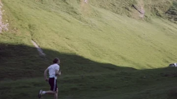 Young trail runner man, running up a mountain hill on grass  Stock Footage 85659017