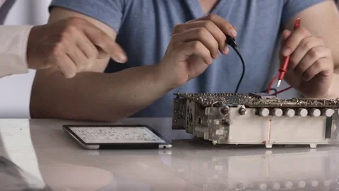 Young trainee testing solder points on old radio after reading construction m Stock Footage 78612032