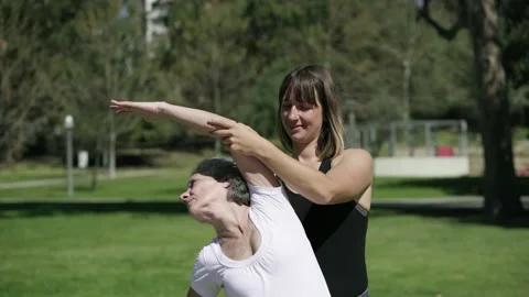 Young trainer teaching senior lady to stretch core muscles Stock Footage 135513026