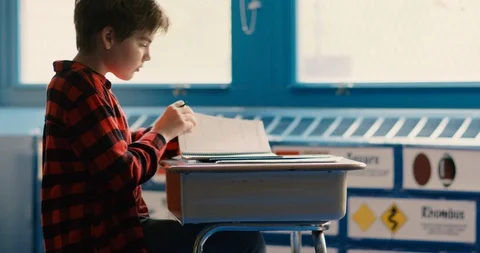 Young transgender boy doing work in school classroom Stock Footage 108787412