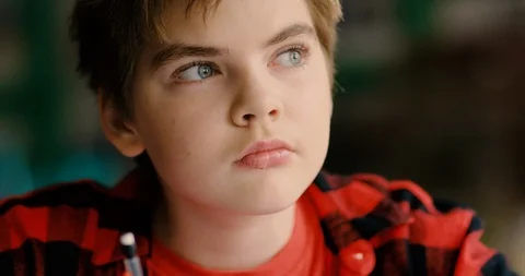 Young transgender boy thinking and working at a desk in a classroom Stock Footage 108791805
