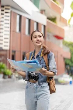 Young traveler reading map while exploring city streets Stock Photos
