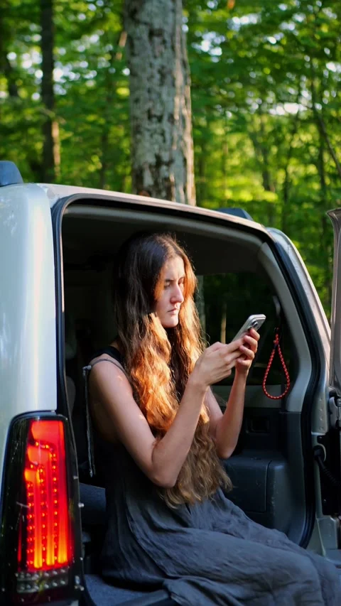 Young traveler using a smartphone from an SUV... Vidéo 340290983