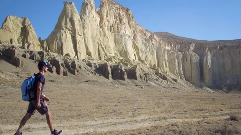 A young traveler walks along a path in a mountainous area Stock Footage 80390908