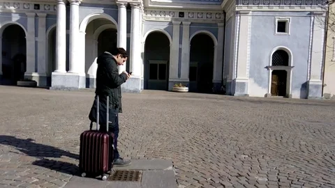 Young traveller checks directions on his smartphone and carries on Stock Footage 86283953