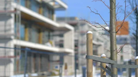 Young trees in front of the construction of a modern building in 4K Slow motion Stock Footage 149006788