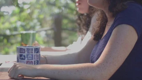 Young twins drinking coffee and talking at a terrace Stock Footage 80383718