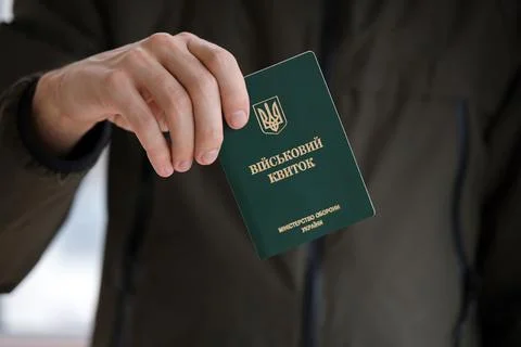 Young ukrainian conscript soldier shows his military token or army ID ticket Stock Photos