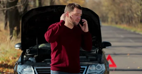 Young unhappy man using smartphone calling car assistance services standing by Stock Footage 165146799