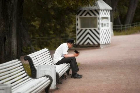 Young uniformed security guard looking at cell phone screen Stock Photos