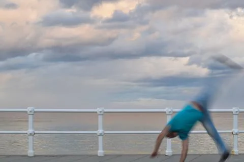 Young unrecognizable man jumping along the promenade. Stock Photos