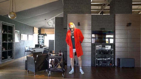 Young unusual guy funny dressed in a red coat Stock Footage 128867452