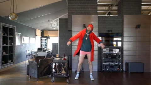 Young unusual guy funny dressed in a red coat Stock Footage 128940366