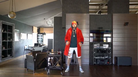 Young unusual guy funny dressed in a red coat Stock Footage 128940535