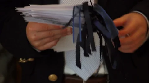 A young usher fusses with programs at a formal event. Close up. Stock Footage 123140084