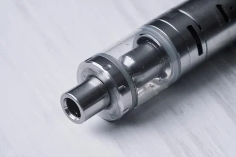 Young vaper man with beard vaping mechanical mod. Guy smokes an electronic ci Stock Photos