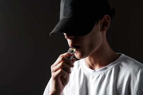 Young Vaper Using E-Cigarette in Dark Setting Stock Photos