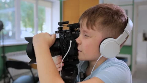 Young videographer engages in creative activity with camera indoors. Video stock 310099500