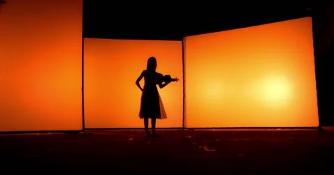 Young violinist playing in front orange panels Vídeo Stock 55652514