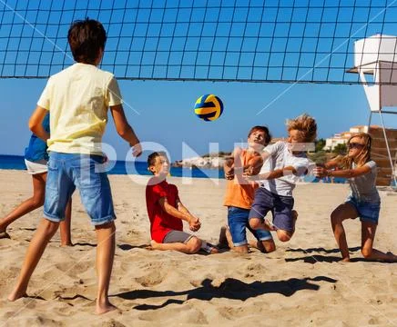 Young volleyball players in action on sand court Stock Photos