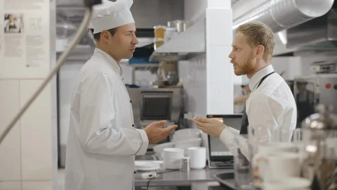 Young waiter writing down chef instructions Stock Footage 125050373