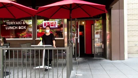 Young waitress working in outdoor seating restaurant during pandemic Stock Footage 159735480