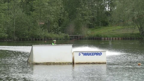 Young wakeboarder does jump over kicker [Slomo] Stock Footage 70133164
