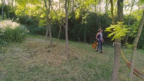 Young walking in the forest with guitar Video stock 76923802