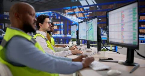 Young Warehouse Worker Uses Computer Software To Track Shipments Efficiently. Fotos Stock