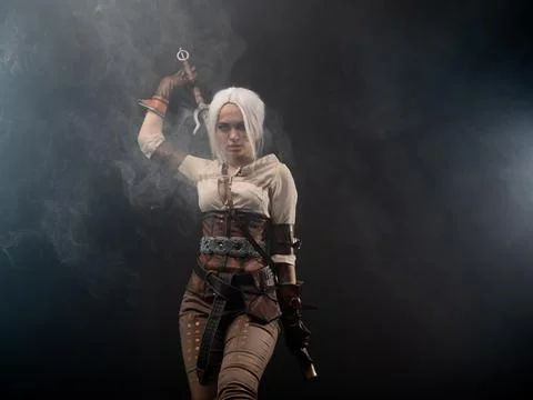 A young warrior with a sword on a dark background. Fantasy heroine Stock Photos