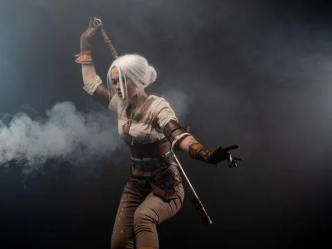 A young warrior with a sword on a dark background. Fantasy heroine Stock-Fotos