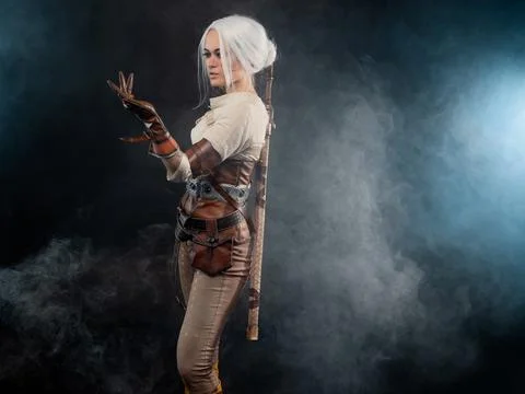 A young warrior with a sword on a dark background. Fantasy heroine Stock Photos