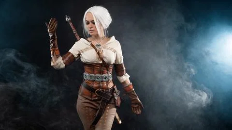 A young warrior with a sword on a dark background. Fantasy heroine Stock Photos