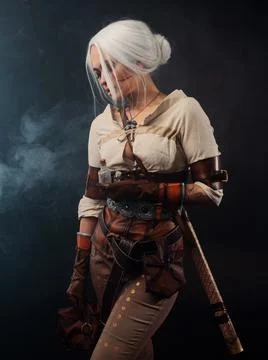 A young warrior with a sword on a dark background. Fantasy heroine Stock Photos