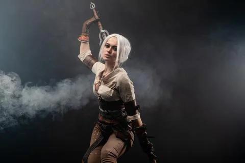 A young warrior with a sword on a dark background. Fantasy heroine Foto stock