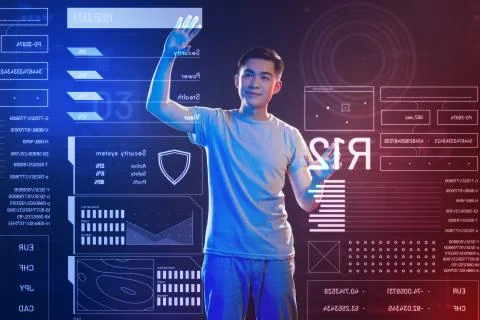 Young web developer smiling and enjoying working with futuristic devices 库存照片