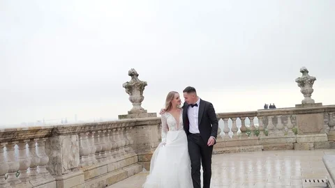 Young wedding couple walking on palace terrace on old city landscape background. Stock Footage 129559012