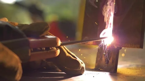Young welder training his dexterity on a piece of metal at a construction site Stock Footage 255684328
