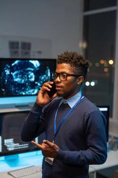 Young well-dressed programmer communicating on smartphone Foto stock